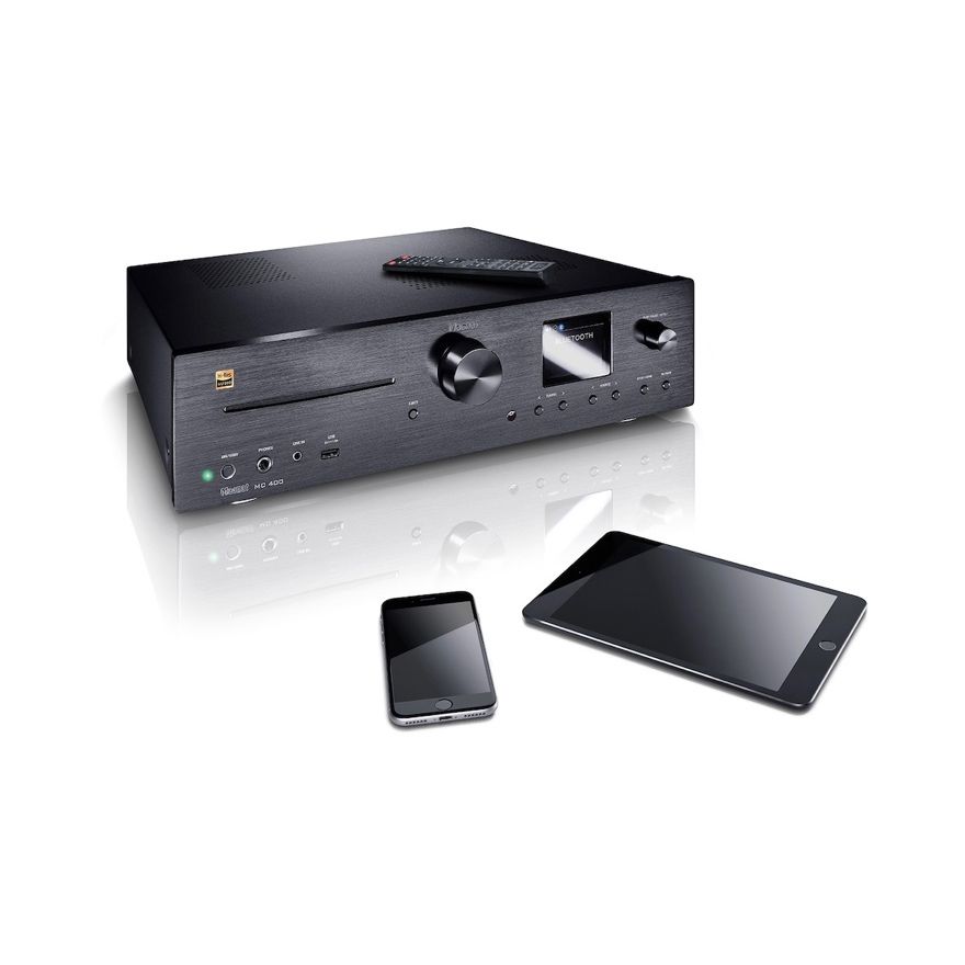 Magnat MC400 abgebildet mit Fernbedienung, Smartphone und Tablet